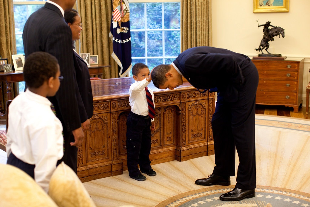 President Obama bends over as 5-year-old Jacob Philadelphia touches his hair.