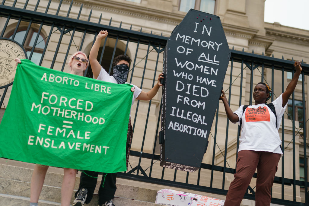 Protesters hold up a coffin in memory of women who have died from illegal abortions