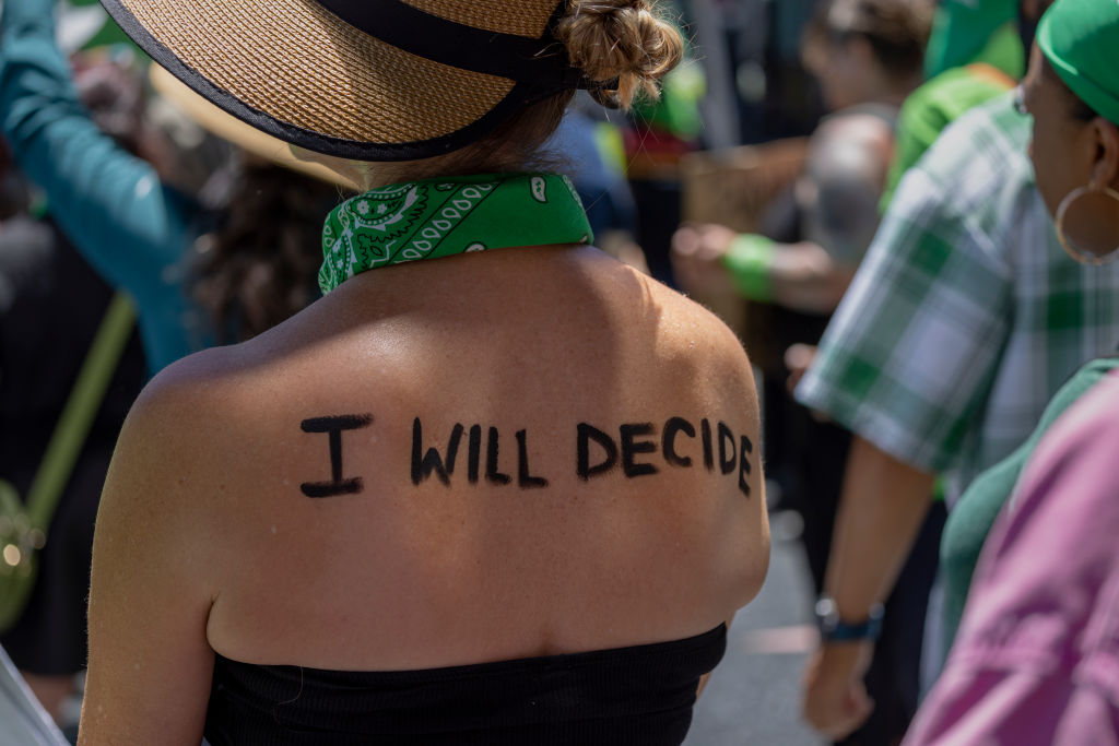 A demonstrator wears a message on her back: "I will decide"