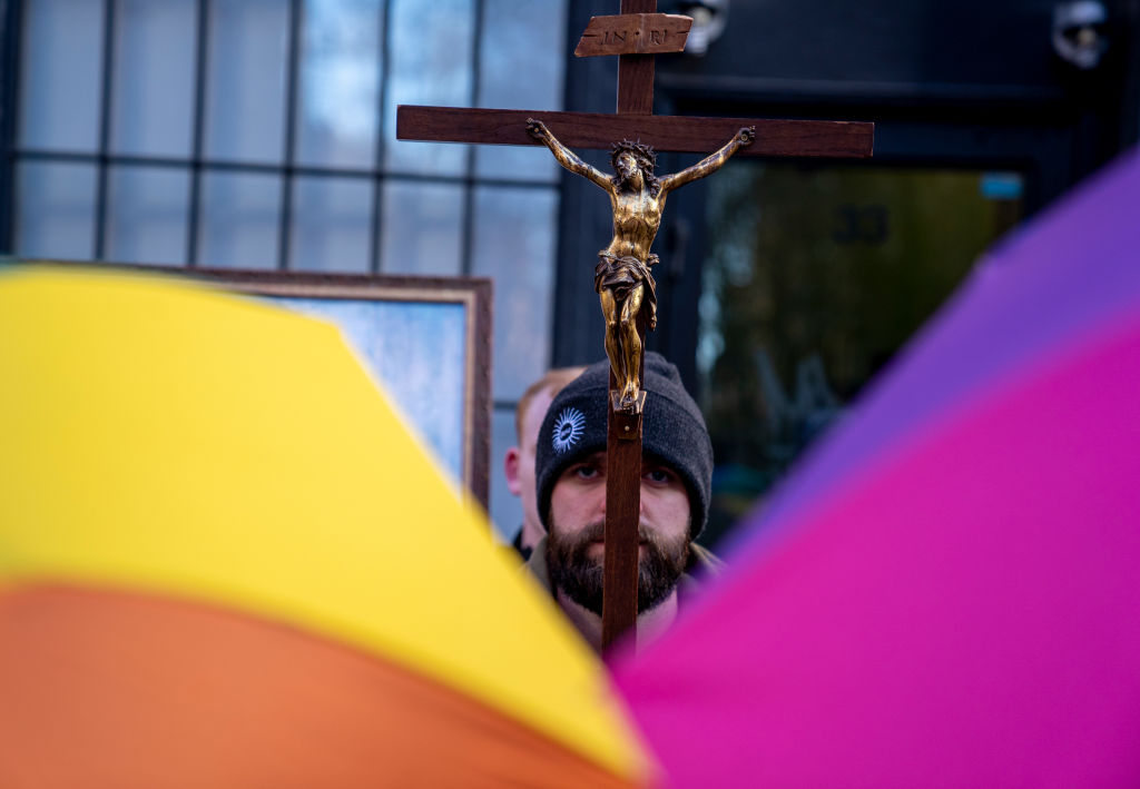 A man holding a cross with Jesus Christ