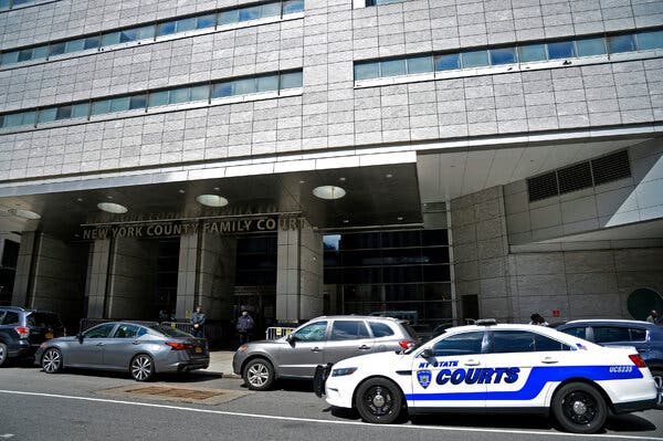 Outside Family Court in Manhattan, with cars parked in the street.